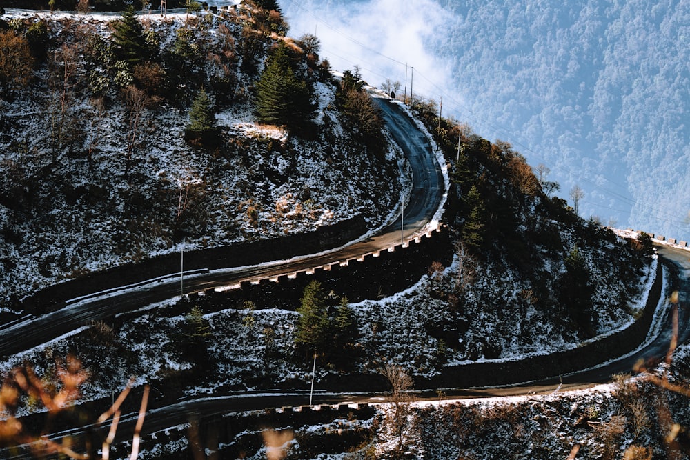 eine kurvenreiche Straße an einem verschneiten Berghang