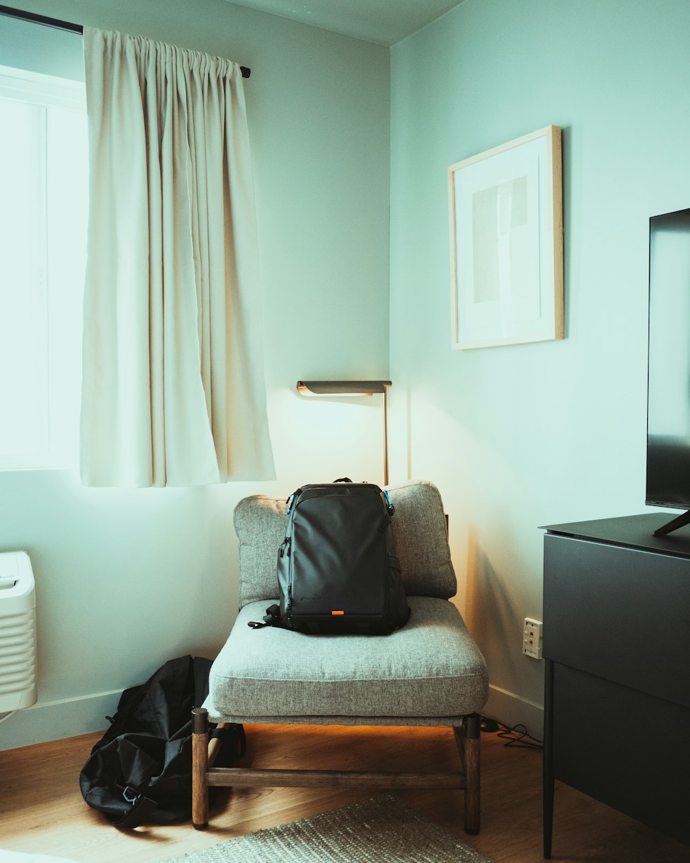 a backpack sitting on a chair in front of a window