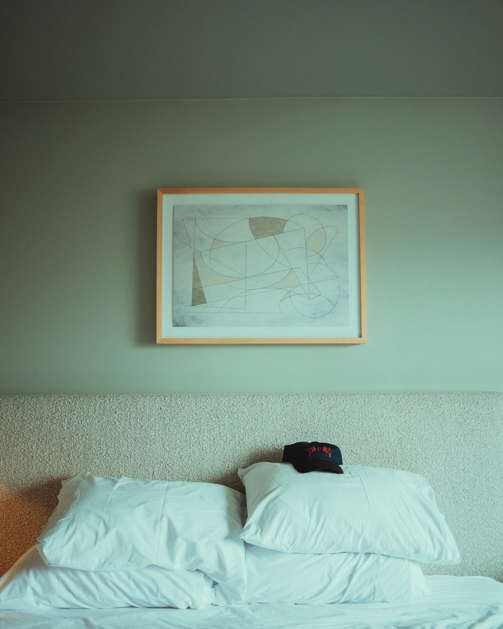 a bed with a white comforter and a picture on the wall