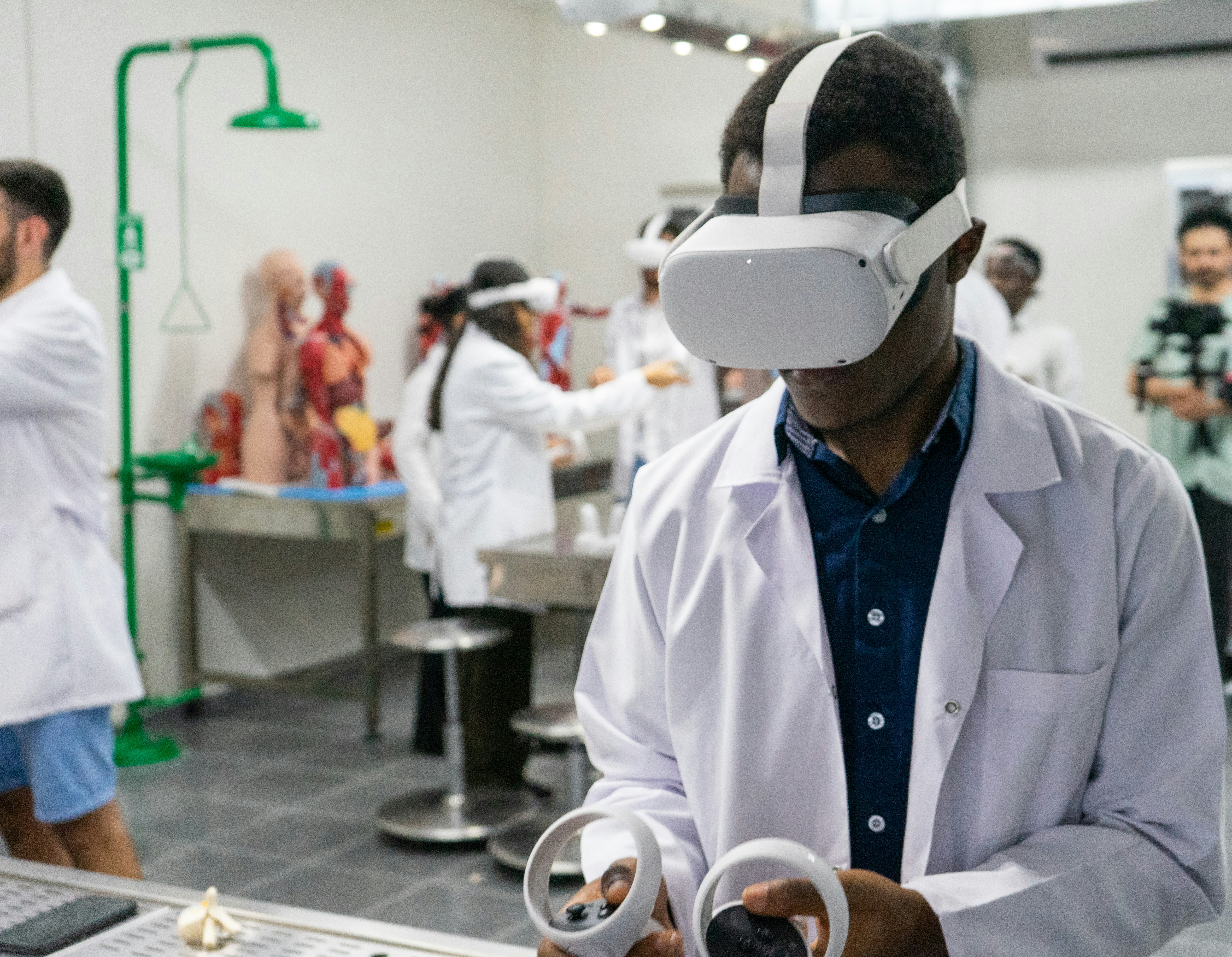 Uomo in camice da laboratorio usa un visore VR in un laboratorio scientifico.