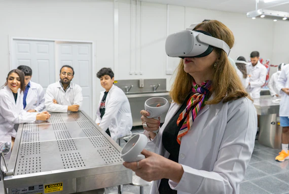 Photo of Fernanda Batista working with virtual reality equipment in a modern research lab setting.