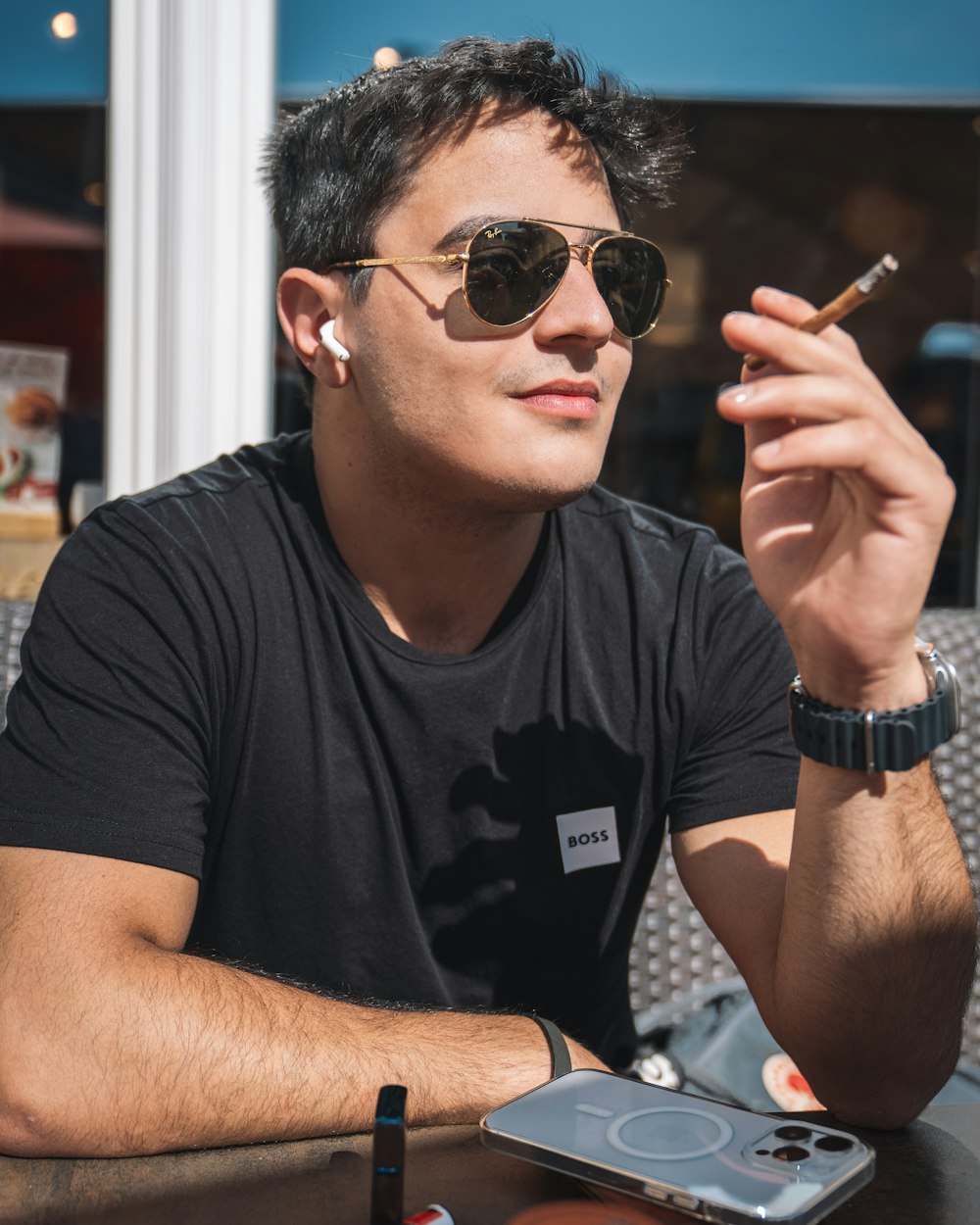 a man sitting at a table smoking a cigarette