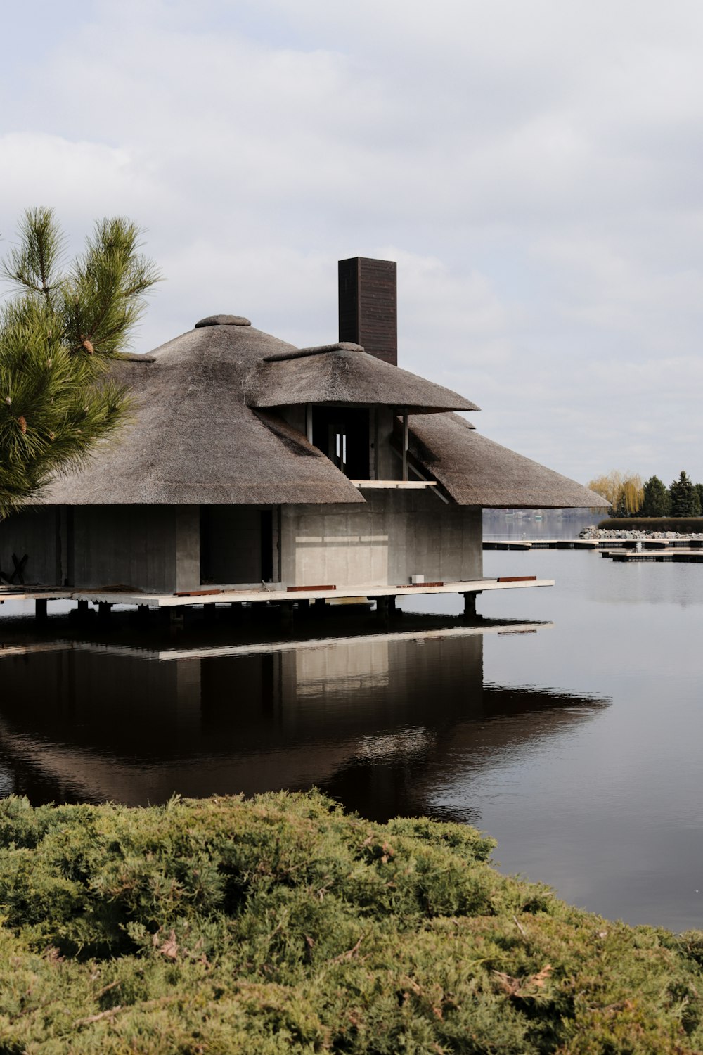 ein Haus, das auf einem See neben einem Wald sitzt