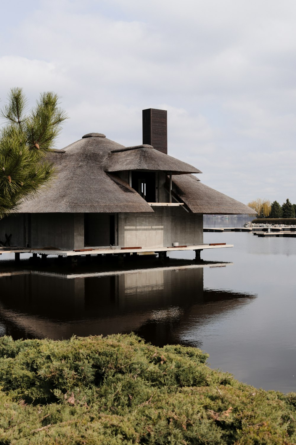 a house sitting on top of a lake next to a forest