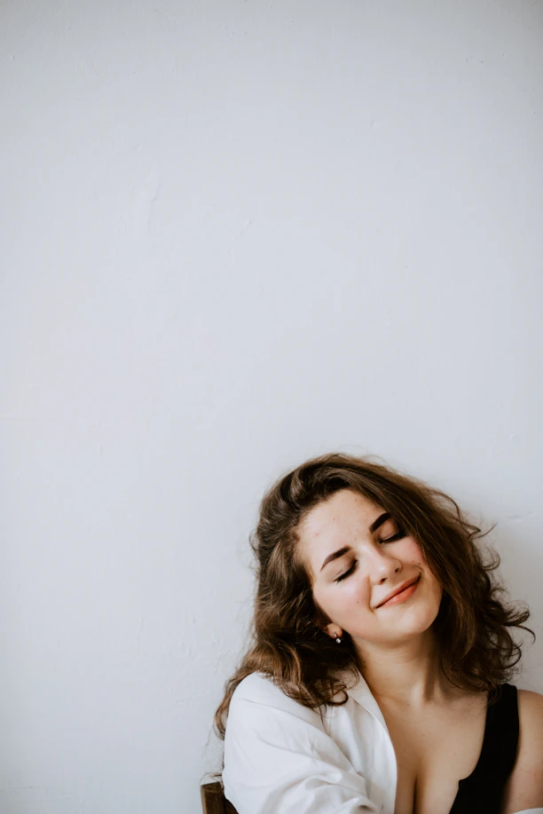 a woman sitting on a chair with her eyes closed