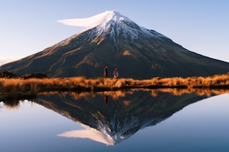 a man and a woman standing in front of a mountain