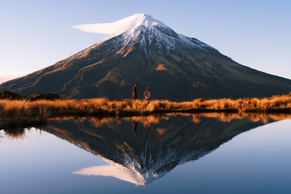 a man and a woman standing in front of a mountain