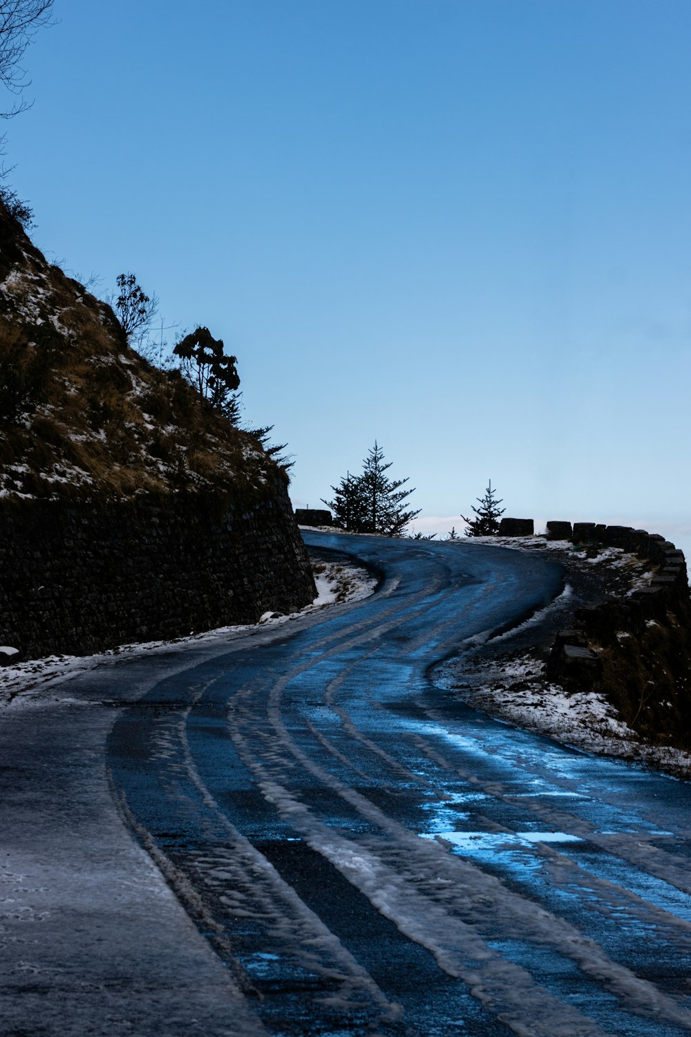 a winding road with snow and ice on the ground