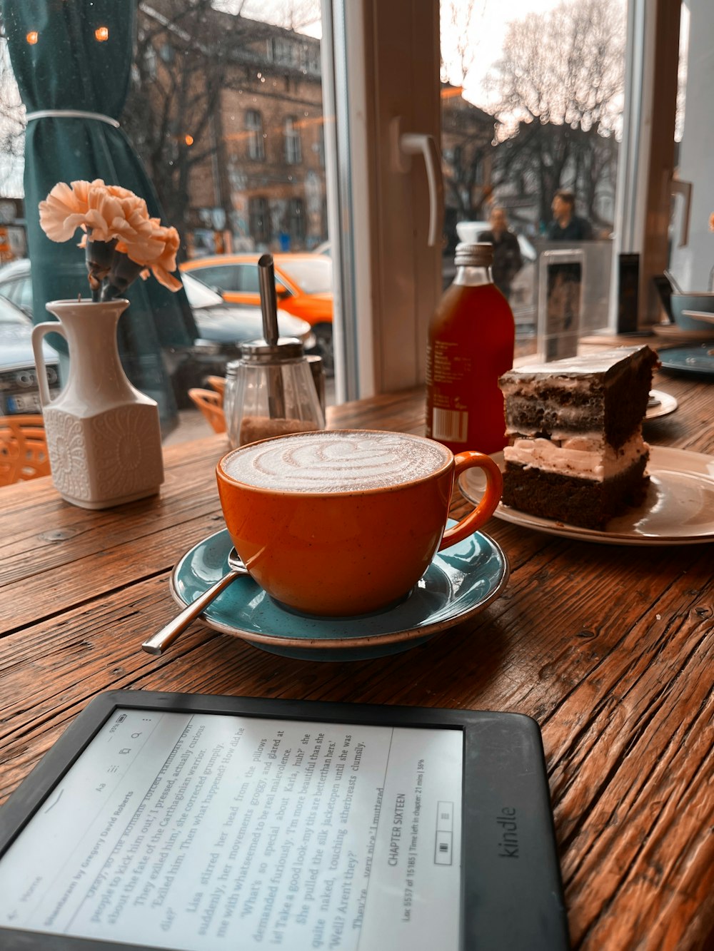 a tablet sitting on a table with a cup of coffee