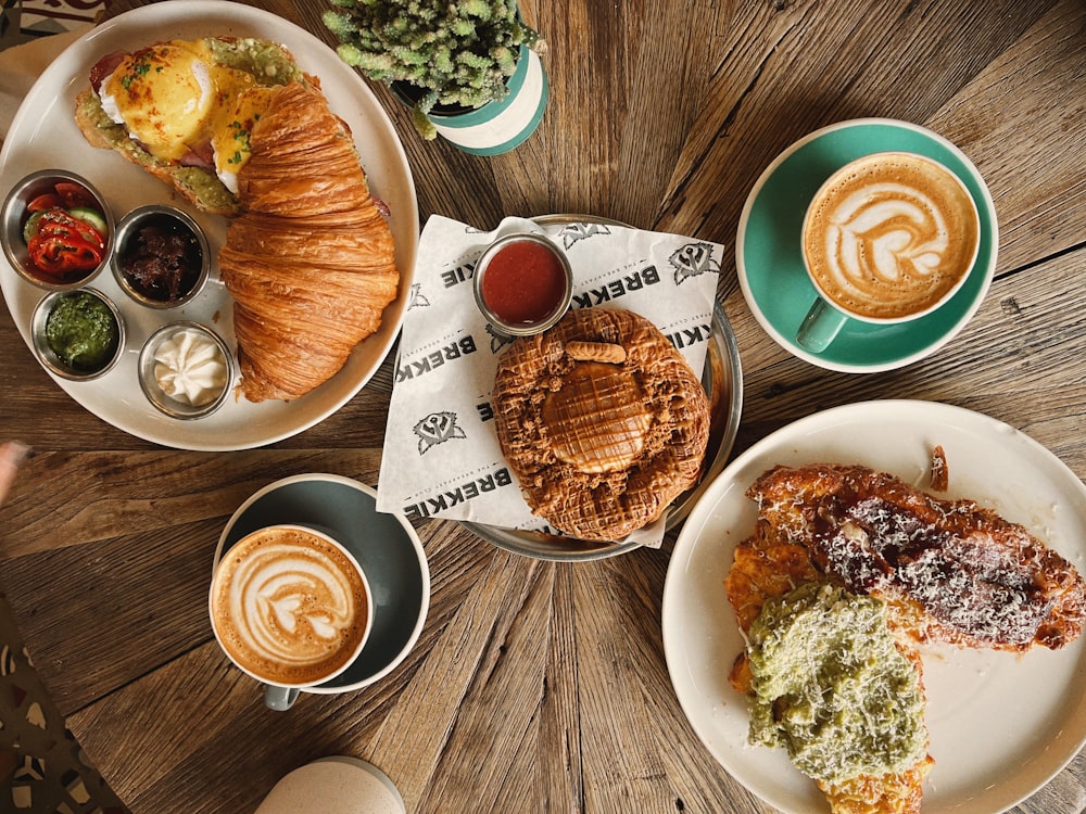 a wooden table topped with plates of food