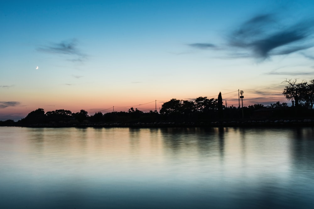 a body of water with a sky in the background