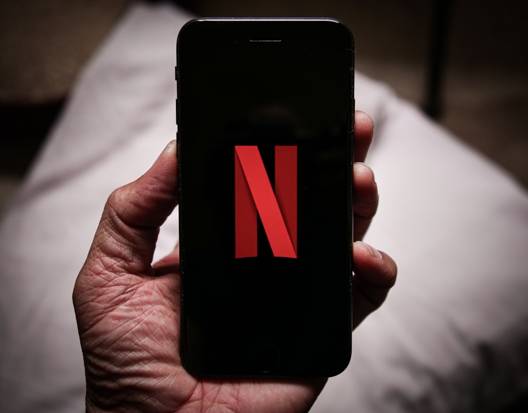 a person holding a cell phone with the letter n on it, -TITLE: Netflix On Cellphone / iPhone -CAMERA: Panasonic Lumix -C