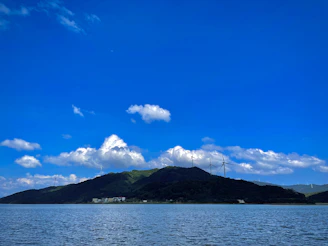 A serene landscape showing a clean fuel storage facility surrounded by green trees under a bright blue sky.