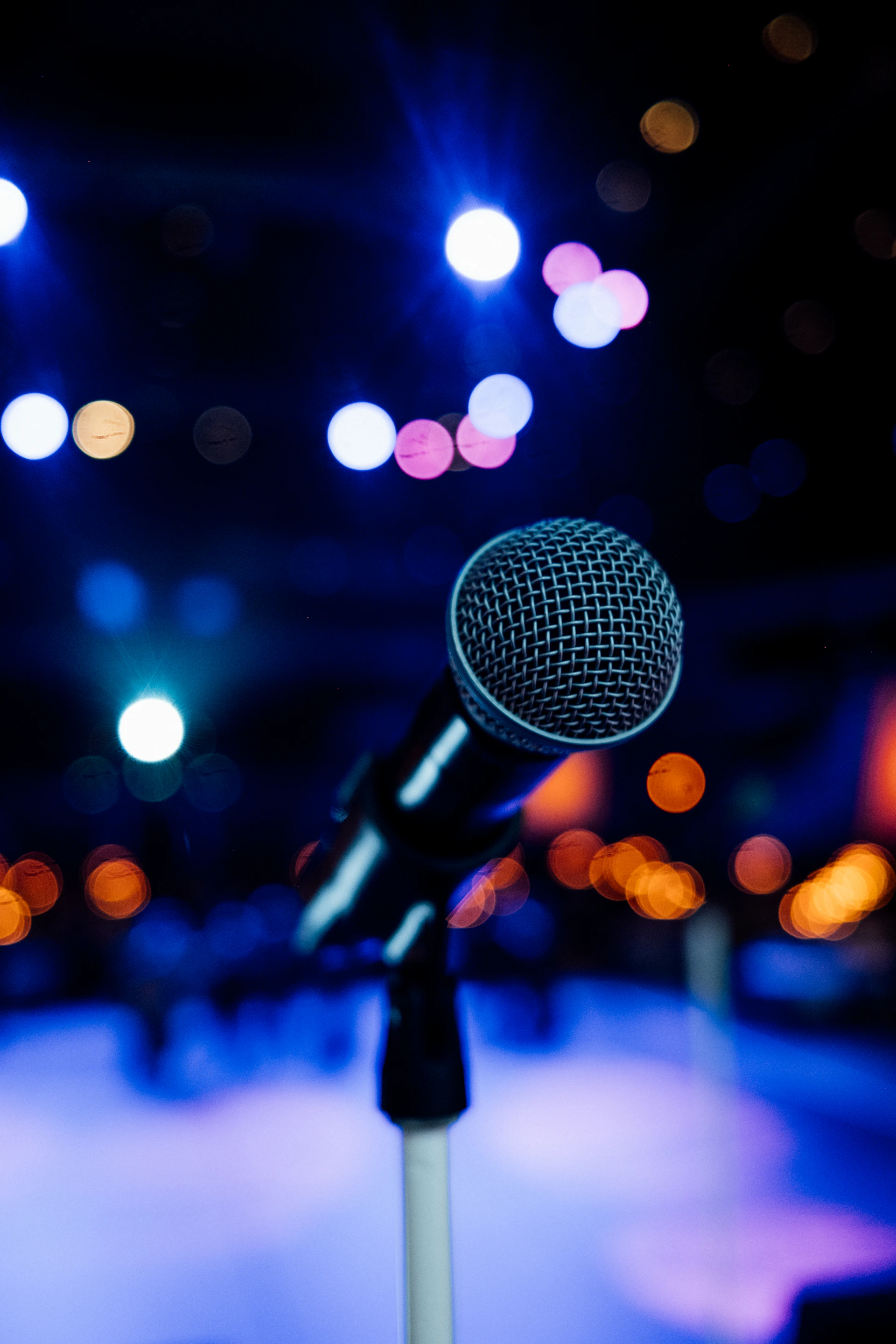 a microphone in front of a stage with lights