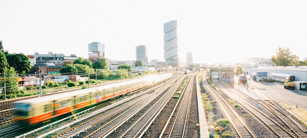 a train traveling down train tracks next to tall buildings