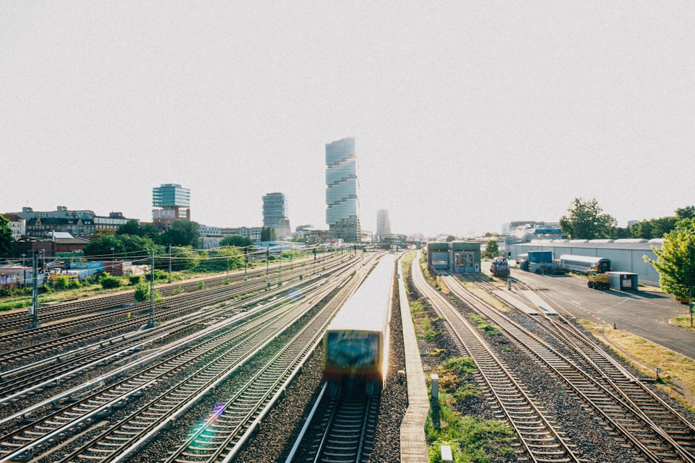 a train traveling down train tracks next to tall buildings