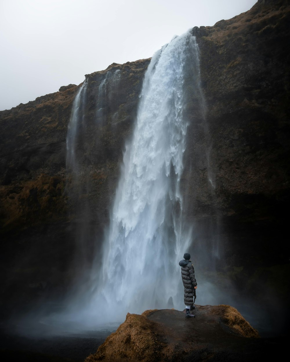 a person standing in front of a waterfall