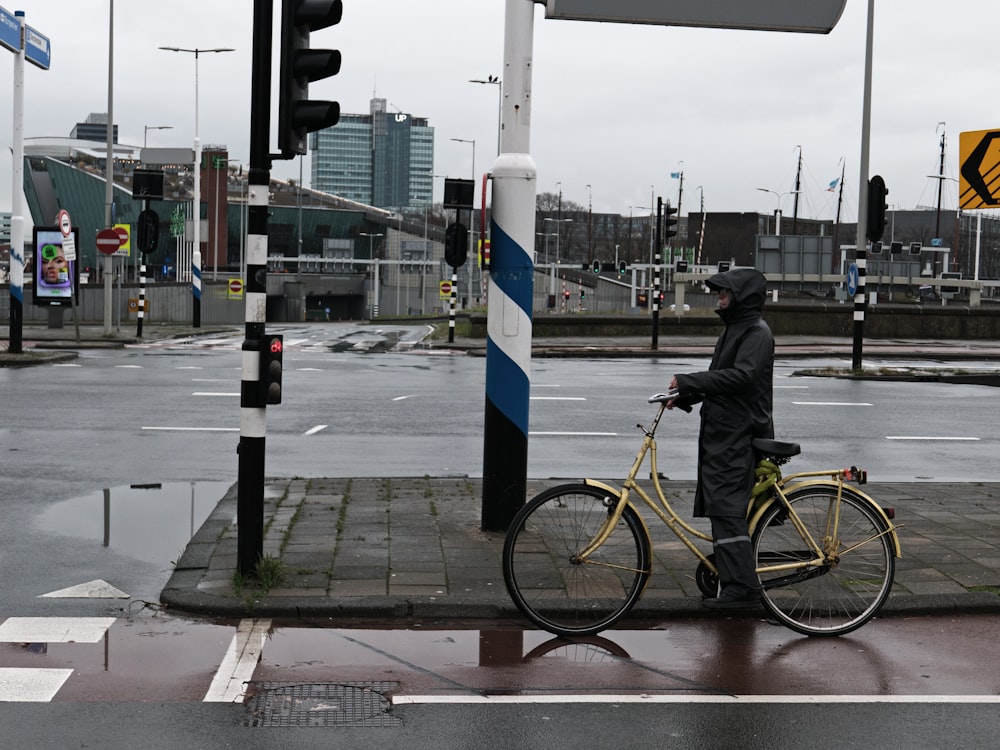 a man on a bike waits at a crosswalk