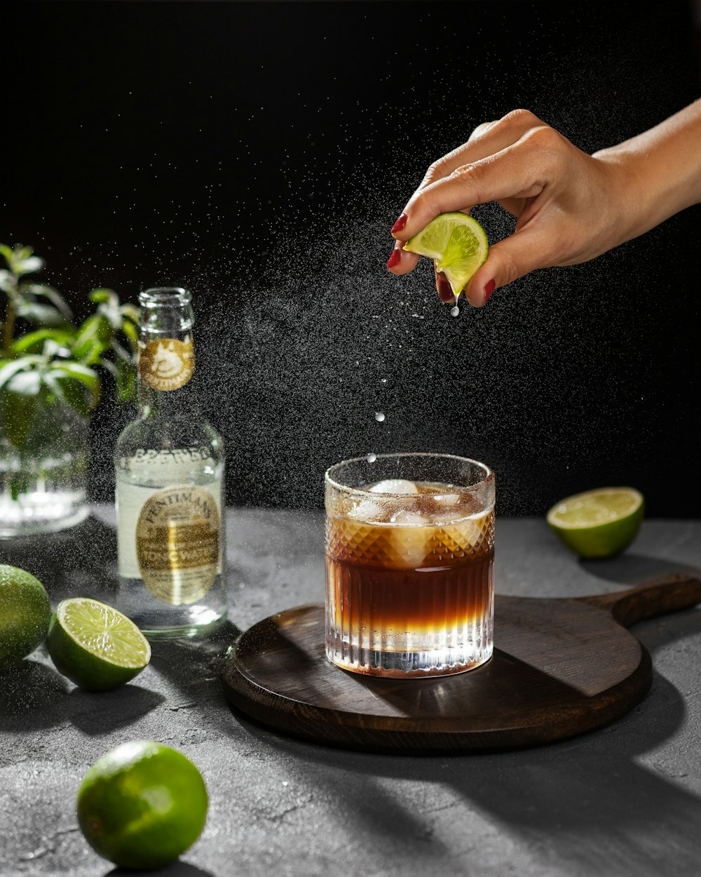 una persona che spruzza un lime in un cocktail