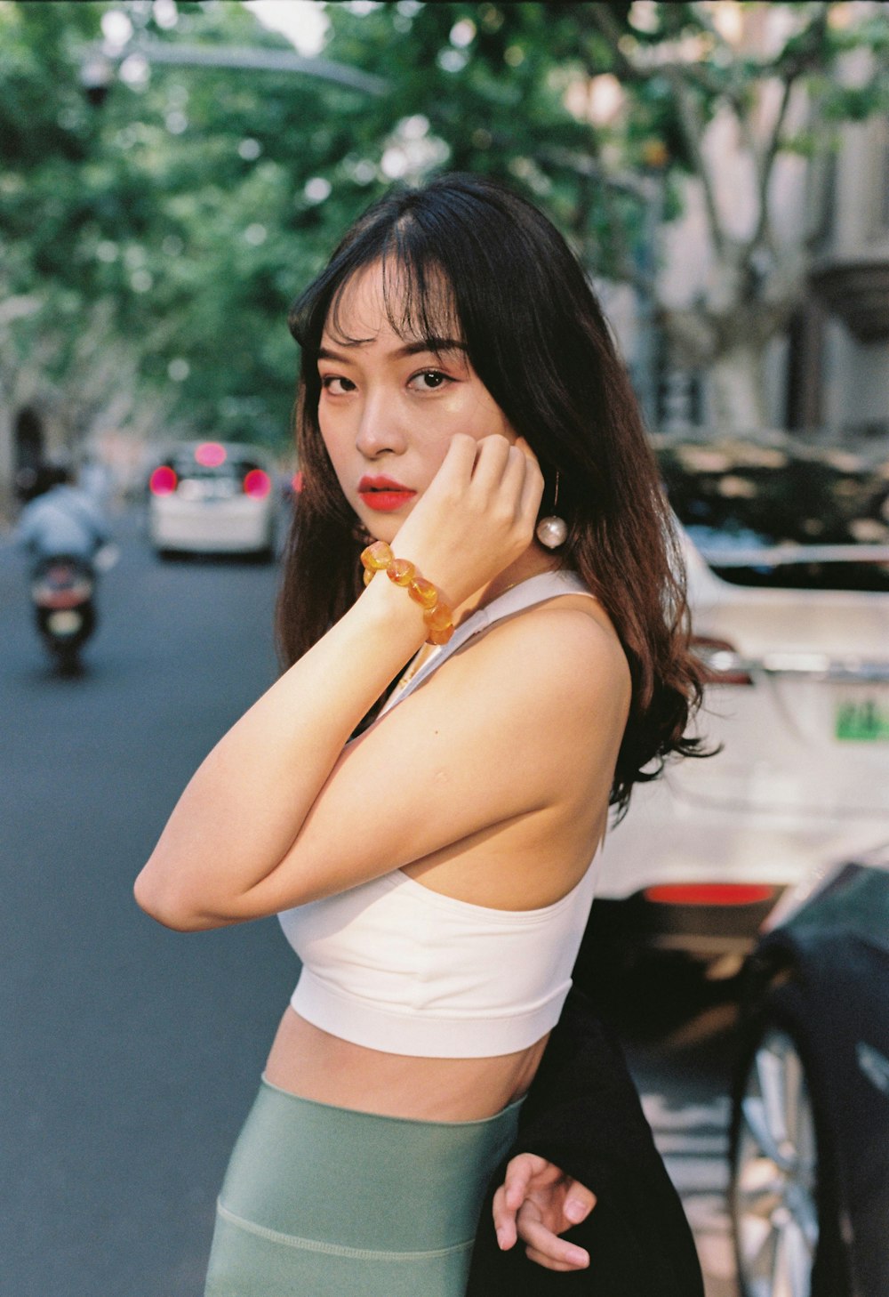 a woman standing on a street while talking on a cell phone