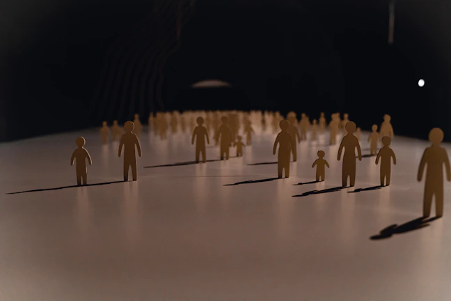 Close-up of colorful laser-cut figures arranged on a wooden table.