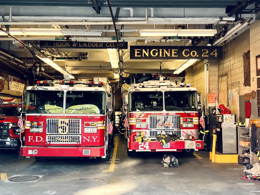 two fire trucks parked inside of a fire station