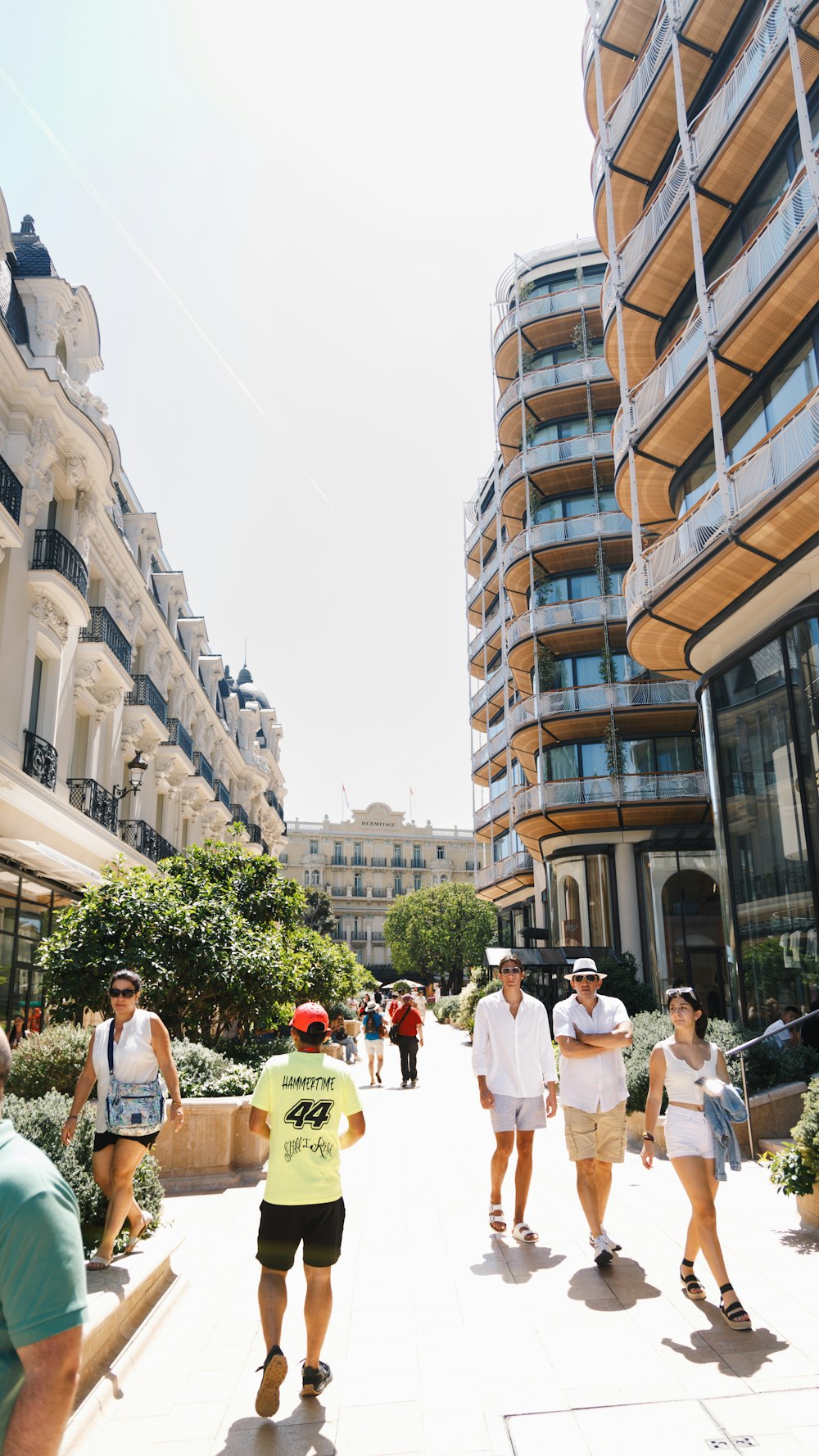 a group of people walking down a street next to tall buildings