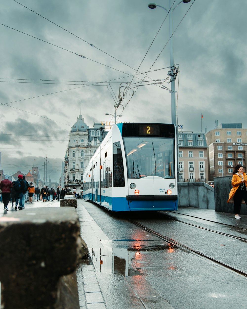 a blue and white train traveling down train tracks