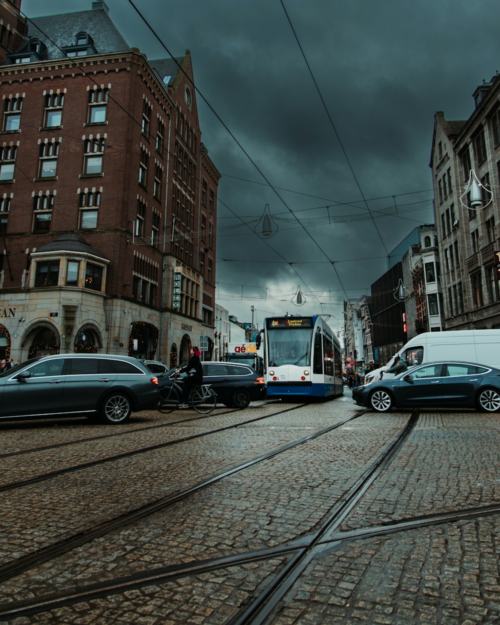 a city street filled with lots of traffic under a cloudy sky