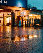 Evening shot of storefronts glowing warmly with inviting lights.
