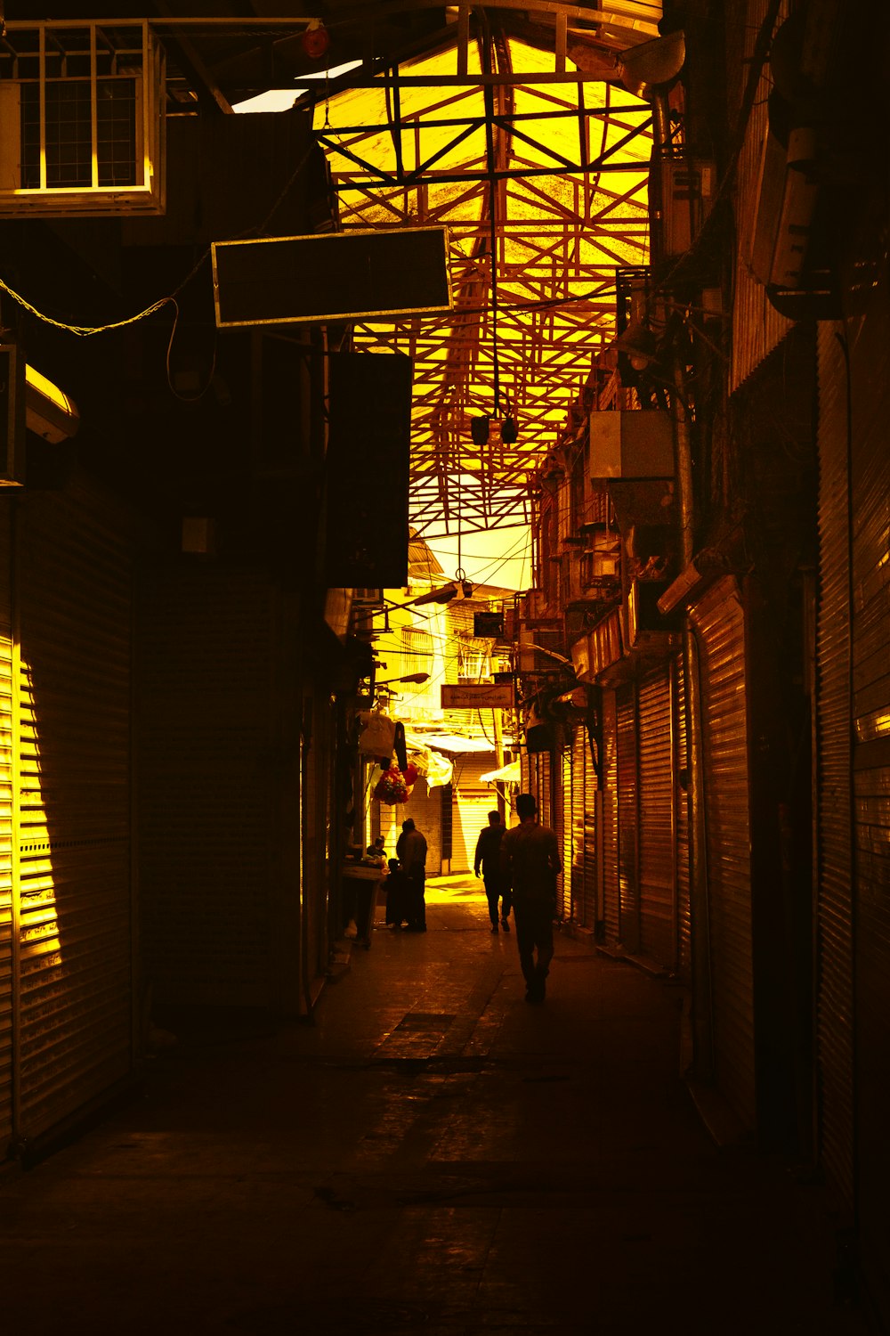 a dark alley way with people walking down it