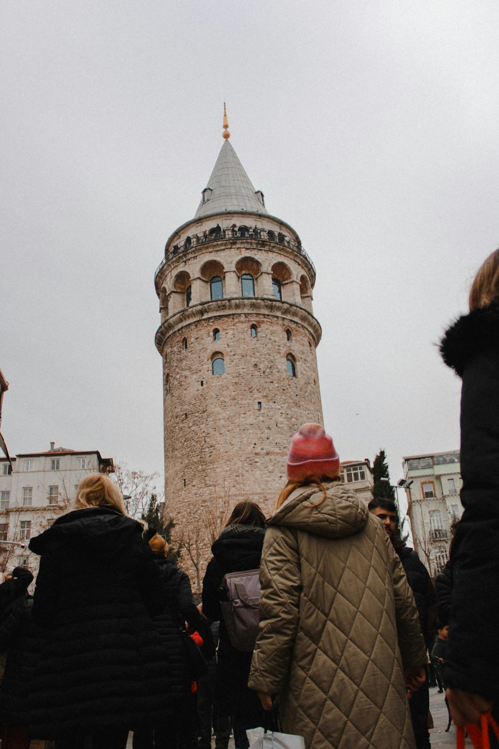 a group of people standing in front of a tall tower