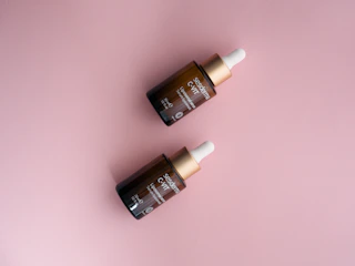 Elegant serum bottle with hyaluronic acid drops on a soft pastel background.