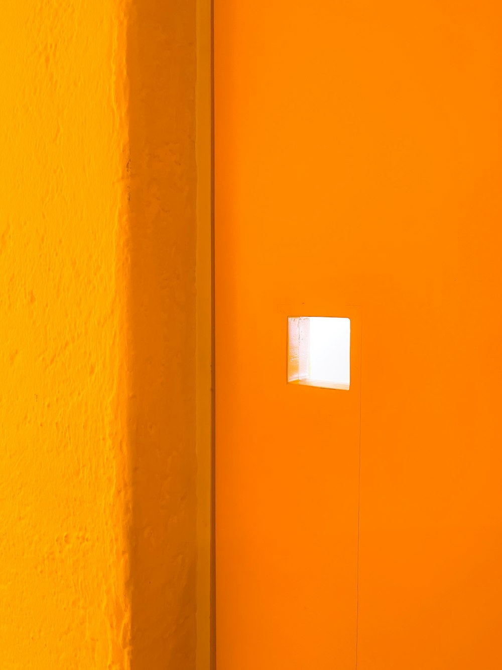 a yellow wall with a white square in the middle