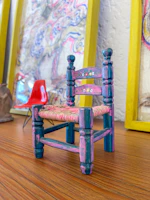 Close-up of a delicate 3D-printed miniature chair with intricate laser-cut details.