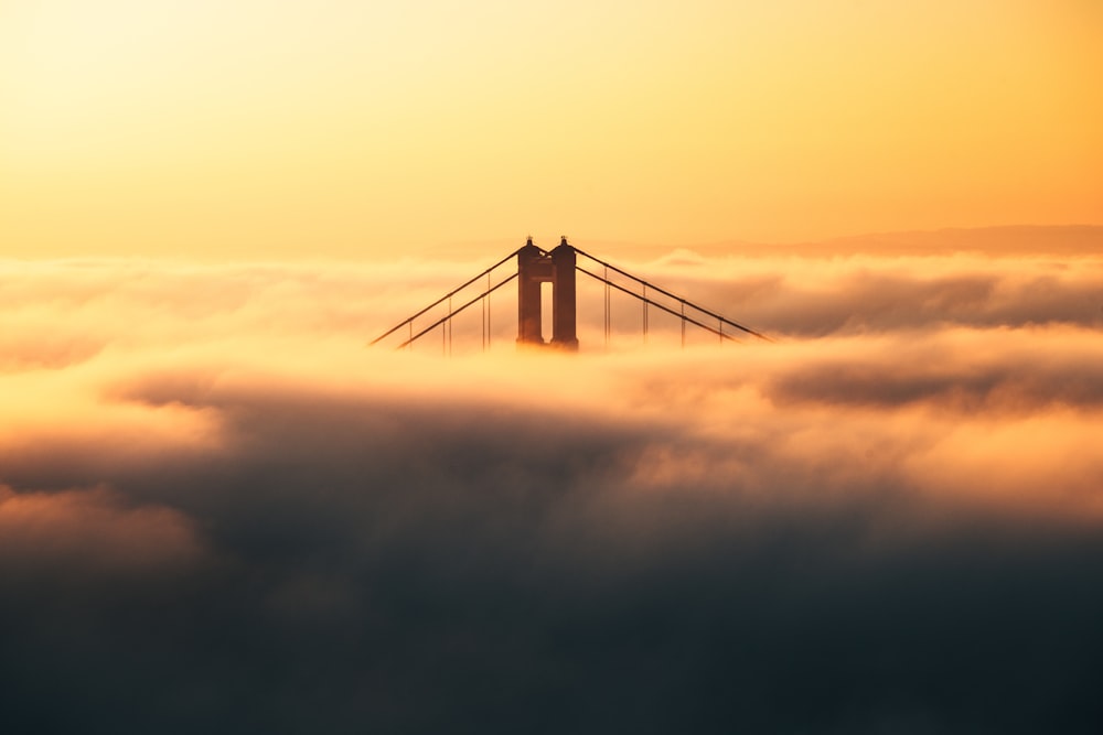 a bridge in the middle of a sea of clouds