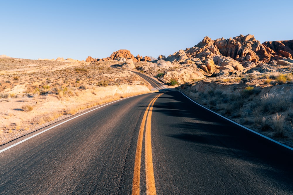 a road in the middle of a desert with mountains in the background