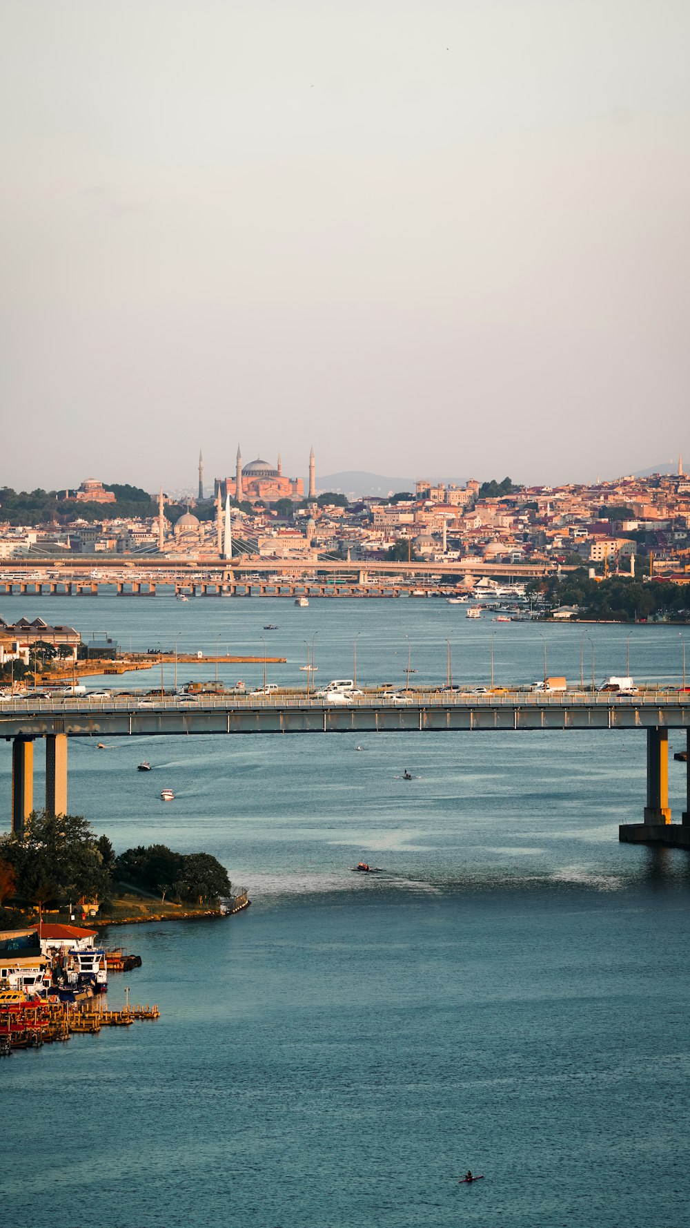 a bridge over a body of water with a city in the background