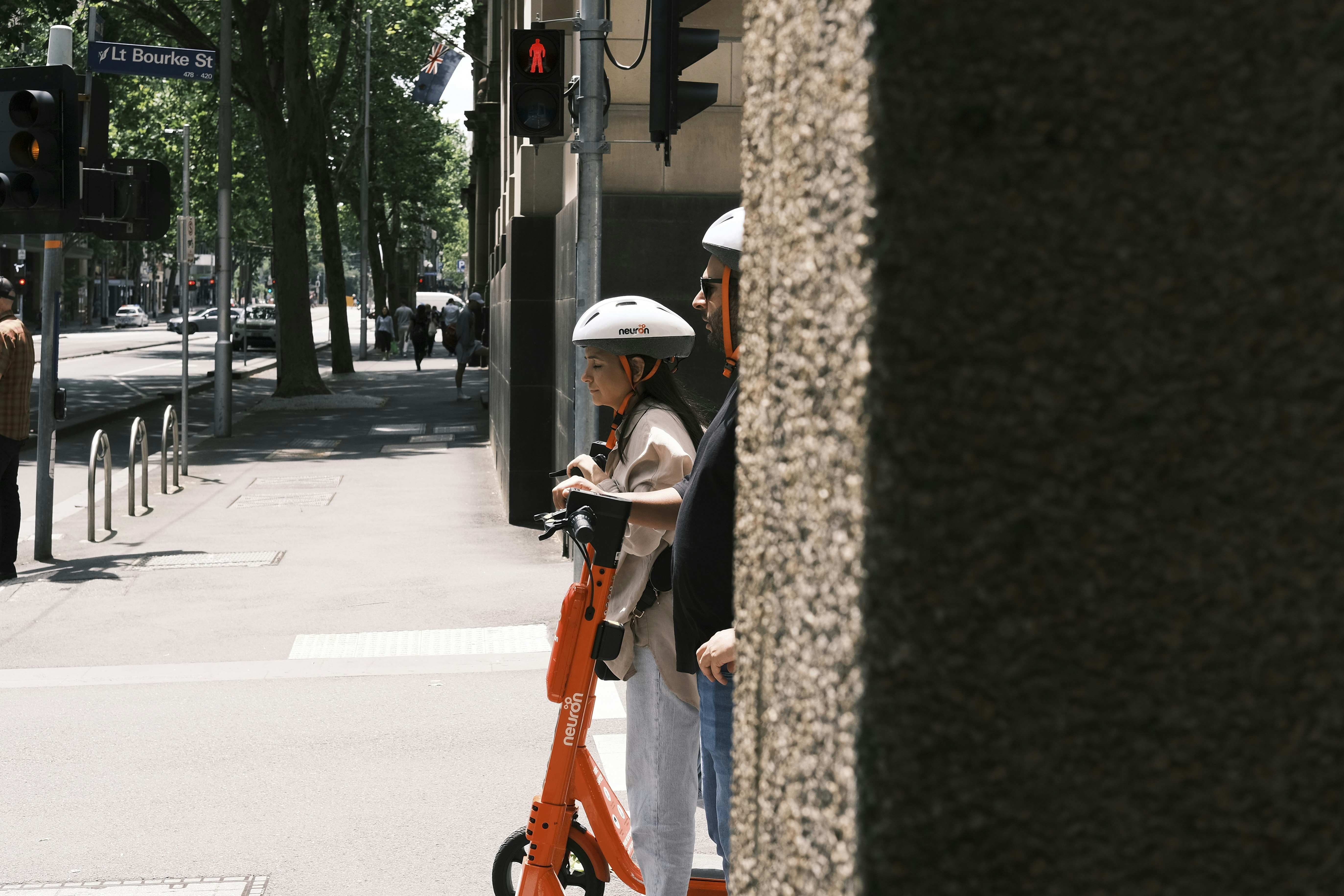 a woman standing next to a man on a scooter