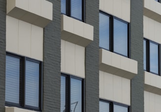 a tall building with many windows next to a clock