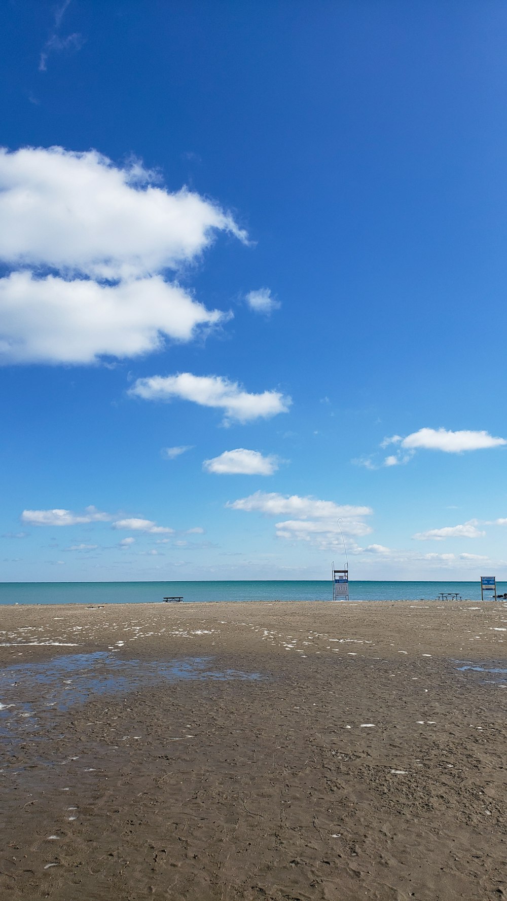 a sandy beach with a few boats in the water