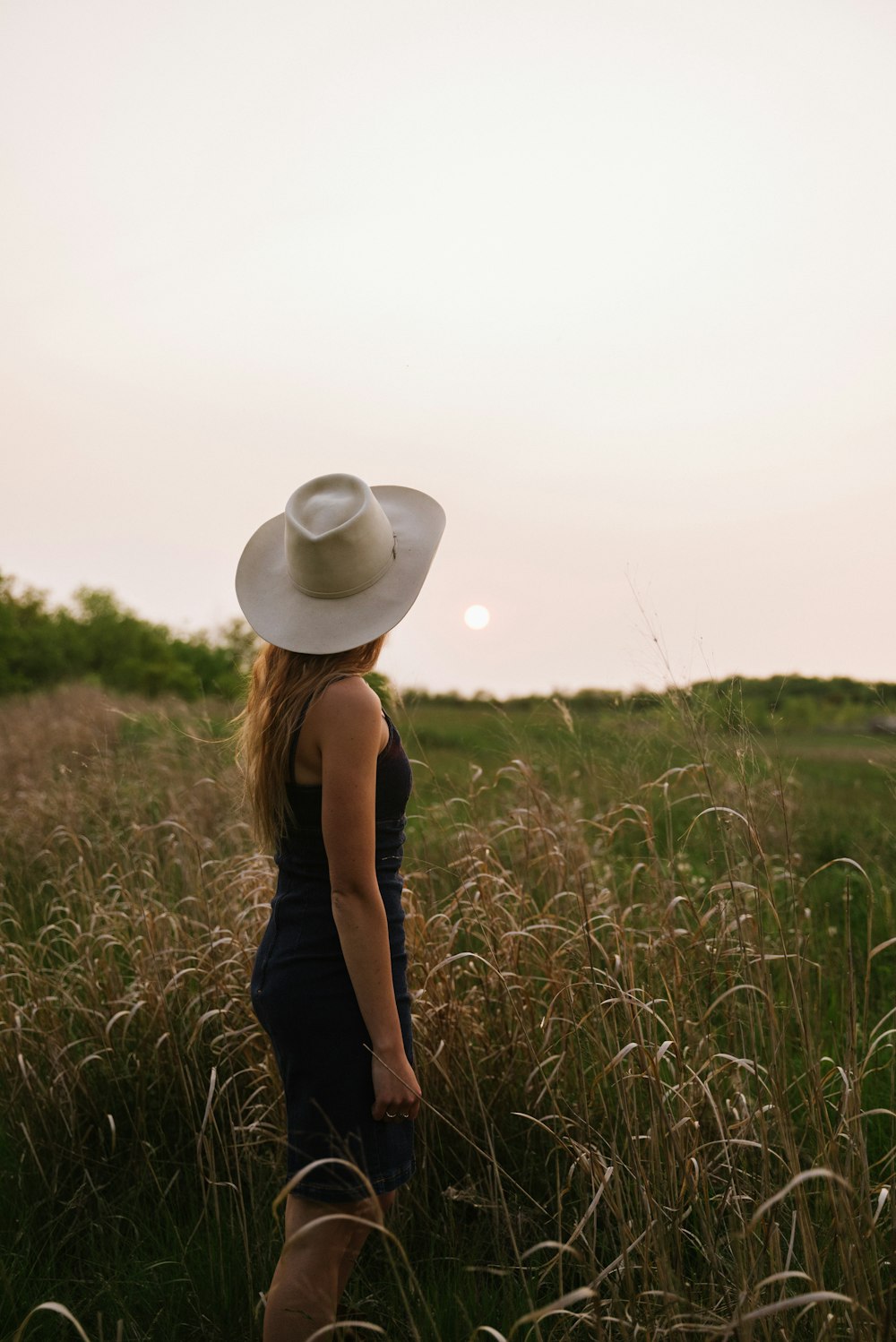 a woman standing in a field of tall grass