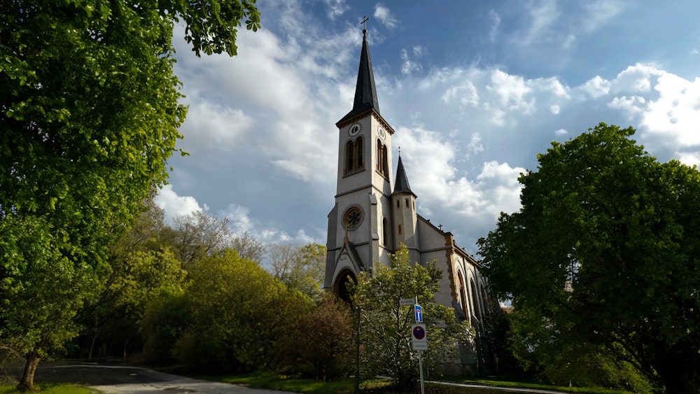 a church with a steeple surrounded by trees