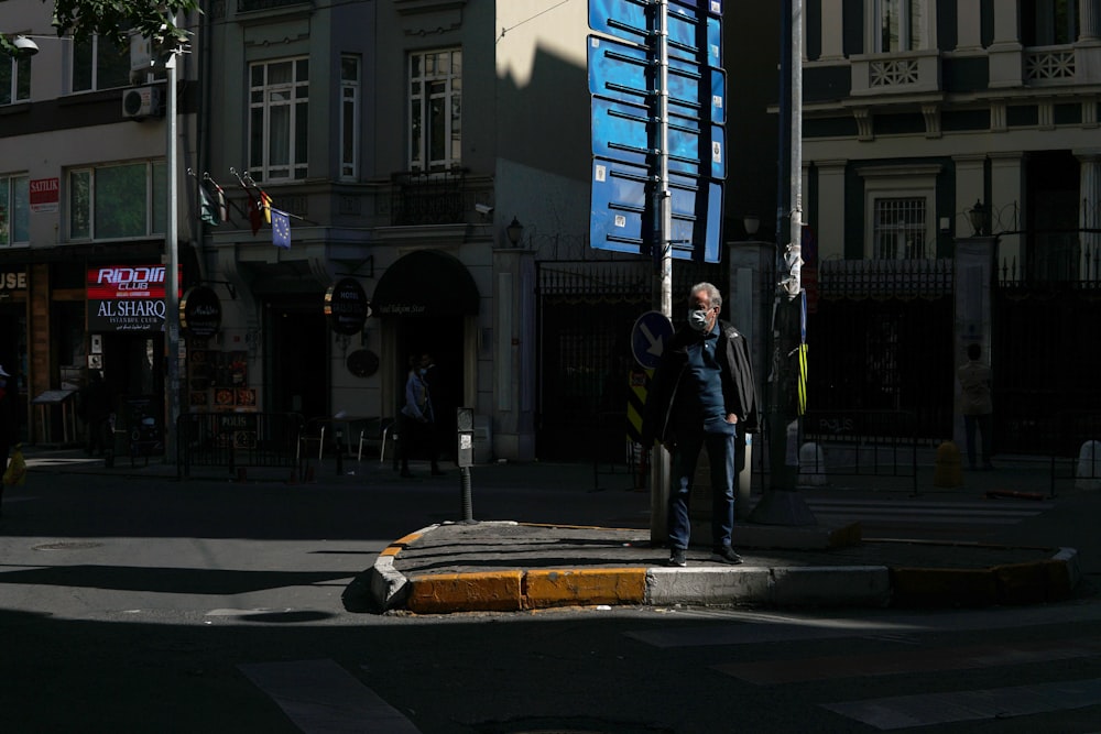 a man standing on the corner of a street