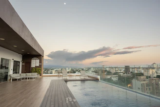 Luxurious rooftop infinity pool overlooking the city skyline at sunset.