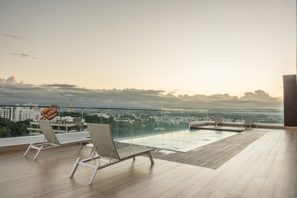 two lounge chairs on a balcony overlooking a city