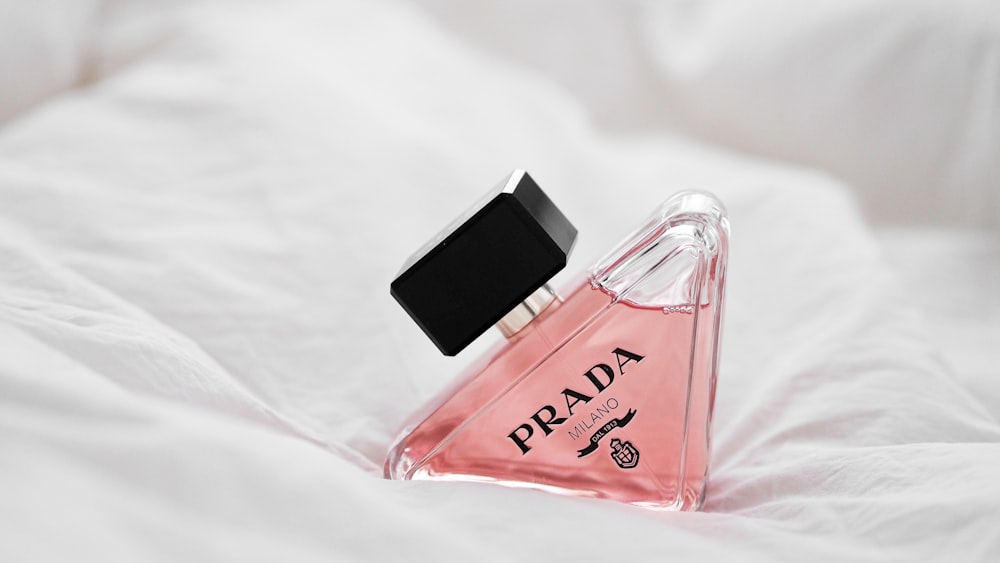 a bottle of perfume sitting on top of a bed