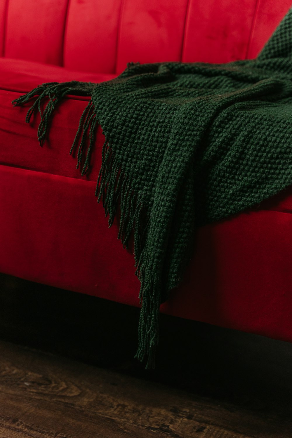 a red couch with a green blanket on top of it