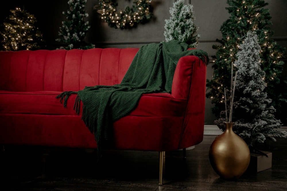 a red couch with a green blanket on it