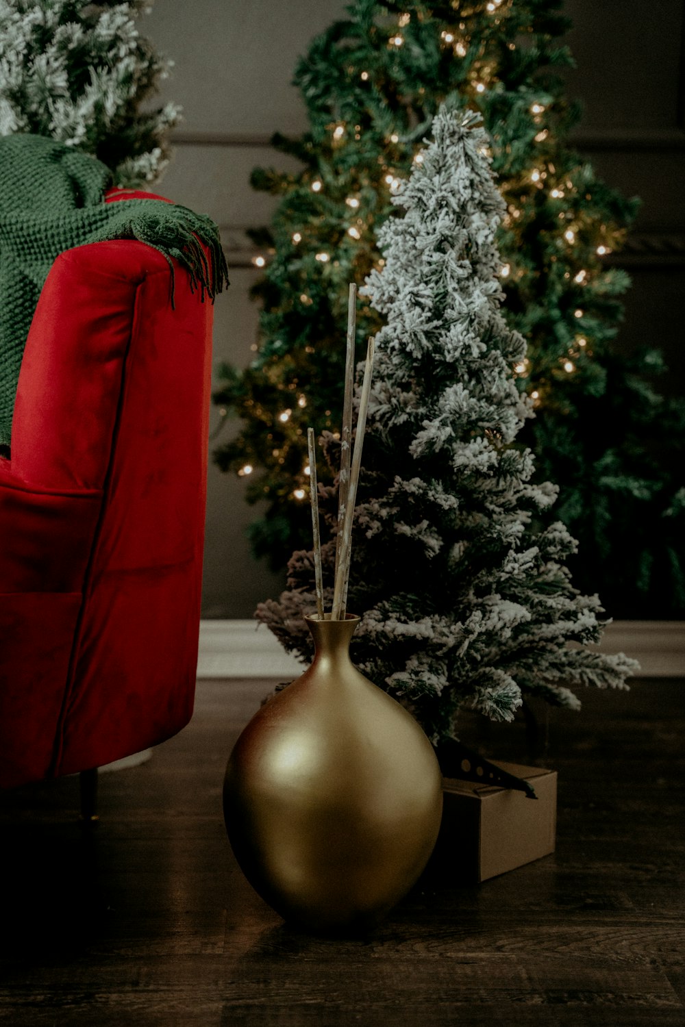 a red chair sitting next to a christmas tree